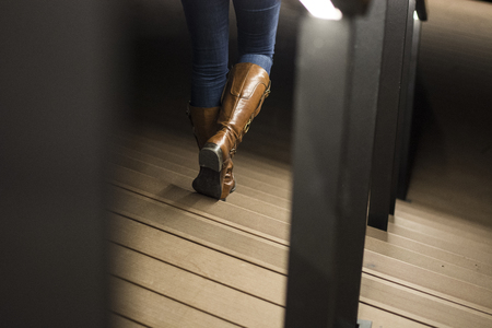 Closeup of leather woman boots on stairs