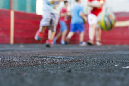 Kids playing football at school playgroundの写真素材