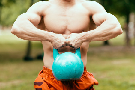 Muscular man exercising with kettle bellの写真素材