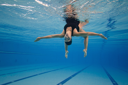Underwater image of a modern dancer performing in a large swimming pool. Post processed, grain added.の写真素材