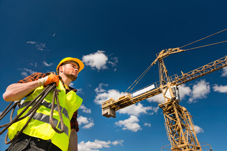 Construction worker with cable under the tower crane