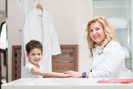 Pediatrician with cute little boy, expressing positivity, gaining confidenceの写真素材