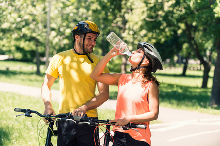 Active couple taking a break after bicycle rideの写真素材