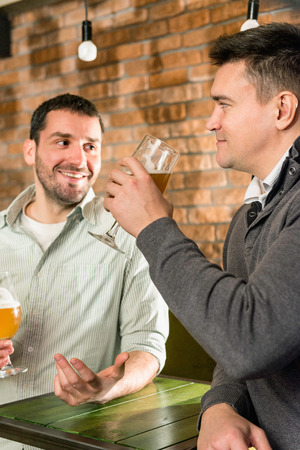 Friends after work, gossiping, drinking beerの写真素材