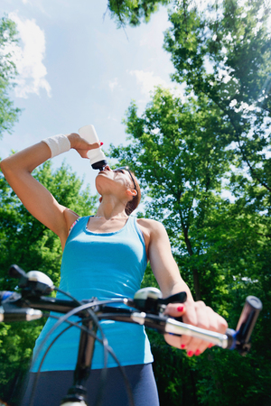 Girl taking a break after bicycle ride through the forestの写真素材