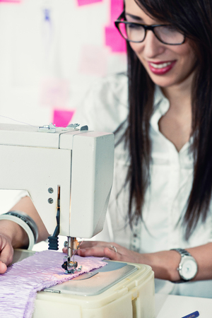 Young woman working with sewing machineの写真素材