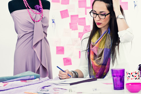 Fashion designer working in studio. Toned imageの写真素材