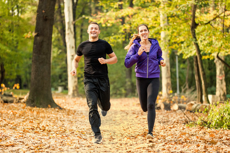 Happy couple jogging in park