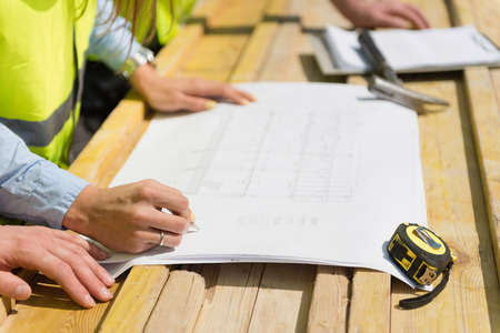 Architect over blueprint on a construction site meetingの写真素材
