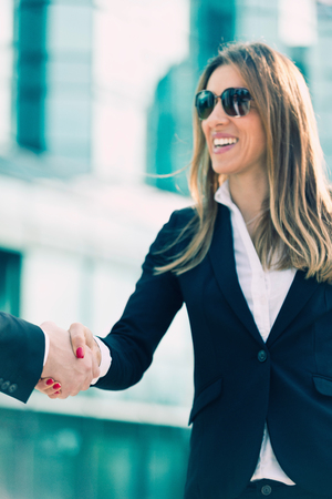 Successful businesswoman shaking hands with business partner. Focus on handshakeの写真素材