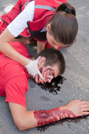 Paramedic performs triple catch medical manouver to enable breathing of an unconcious  car accident victimの写真素材