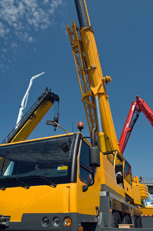Mobile construction crane with some more lifters in the backの写真素材