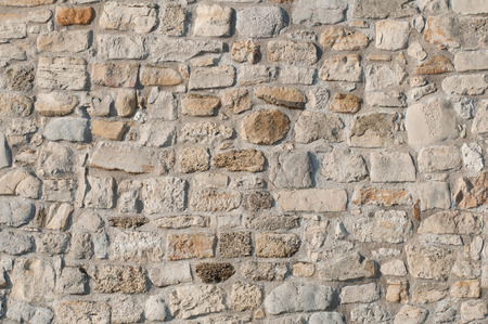 Large rough stone wall, deep focus convenient for backgroundsの写真素材
