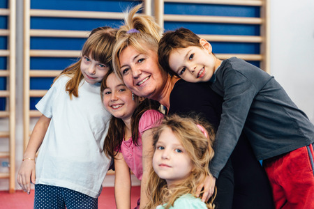 Group portrait of children with physical education teacher in school gymnasium