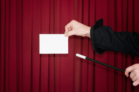 Magician presents blank card on stage. Low keyの写真素材