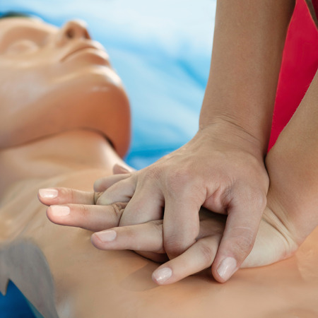 Chest compression demonstration on CPR doll by womanの写真素材