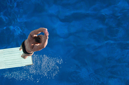 Male diver bouncing on the springboard before the dive.