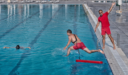 Lifeguard training course - rescuing victim from swimming poolの写真素材