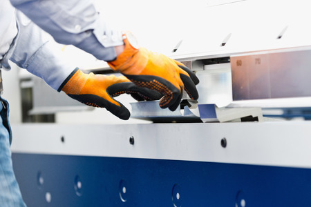 Operator working on industrial tin folding machineの写真素材