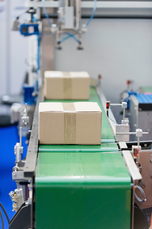 Production line - boxes moving on a conveyor beltの写真素材