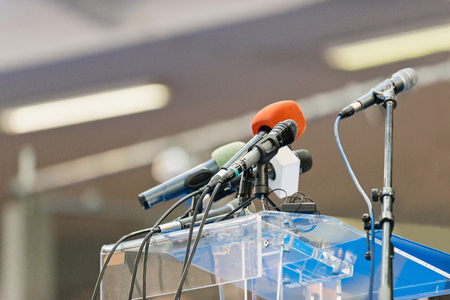Empty tribune with microphones ready for conferenceの写真素材