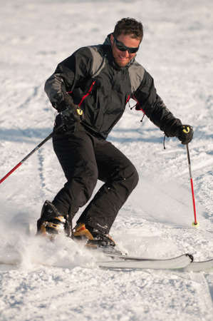 Young men skiing on a snowy mountainの写真素材