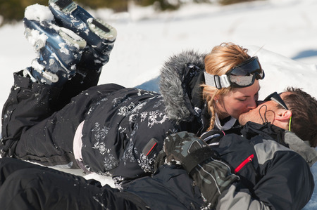 Young couple in love kissing on the snowの写真素材