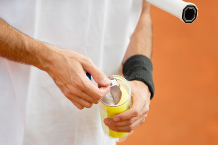 Tennis player opening new pack of balls