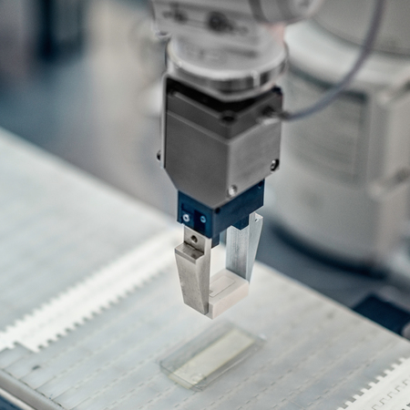 Articulated robotic arm working on a conveyor belt in a high tech factory