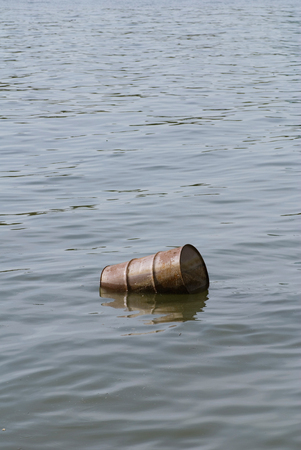 Water pollution - floating oil barrel in the polluted riverの写真素材
