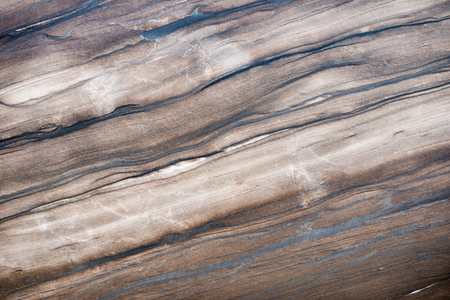 Cross section of a huge, beautifully layered, natural brown granite stone block. Convenient for backgrounds.の写真素材
