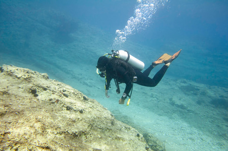 Scuba diver underwater exploring coral reefの写真素材
