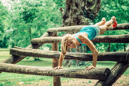 Female athlete doing push-ups on a fitness trail