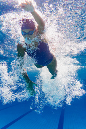 Front crawl young female swimmer underwaterの写真素材