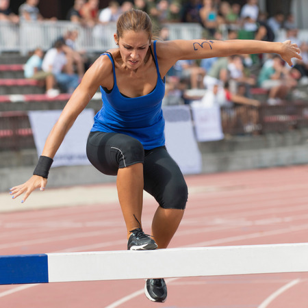 Athlete crossing obstacle at steeplechase courseの写真素材