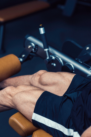 Muscular man exercising in gym, leg extension machine workoutの写真素材