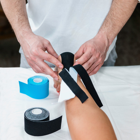 Placing kinesio tape on patient's footの写真素材