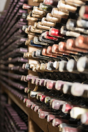 Assortment of old wine bottles in a cellar. Selective focus, mold and dust visible, all identifying marks removedの写真素材