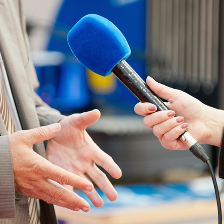 Journalist interviewing a businessmanの写真素材