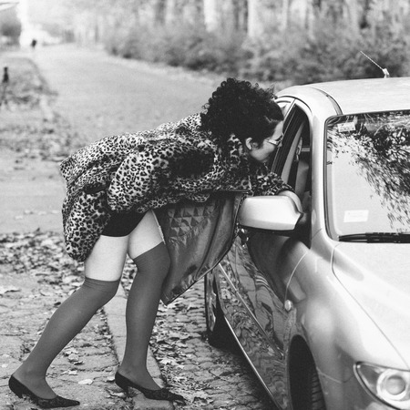 Prostitute showing her attributes to car driverの写真素材