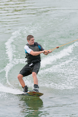 Young man wakeboarding on lakeの写真素材