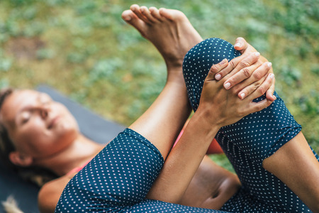 Young woman doing Yoga, detail from reclining position, focus on handsの写真素材