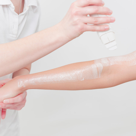 Beautician waxing woman's arm in beauty salonの写真素材
