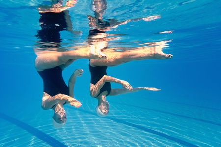 Synchronized swimming duet - underwater viewの写真素材