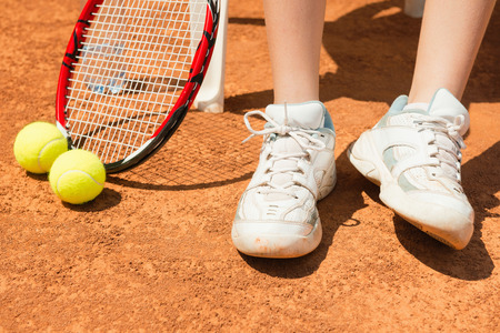 Tennis player on break, focus on tennis shoes, racket and ballsの写真素材