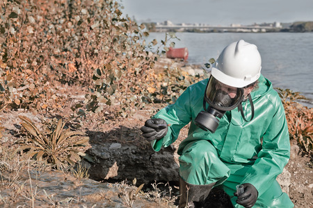 Pollution control official taking sample of mud in the fieldの写真素材