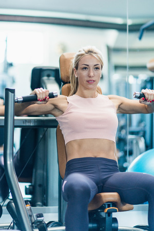 Gym Training - Beautiful young woman exercising in gymの写真素材