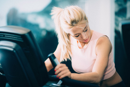 Treadmill workout - Attractive female athlete exercising on treadmill in the gymの写真素材
