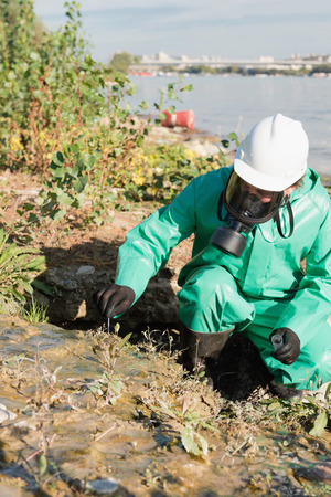 Pollution control official taking samples of soil at pollution siteの写真素材