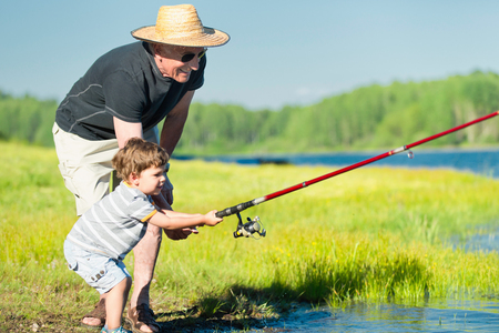 Grandson and grandfather fishing togetherの写真素材